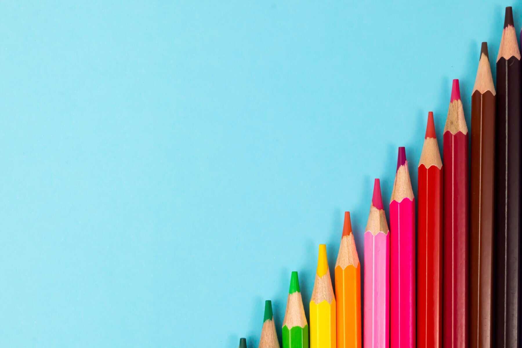 different colored pencils with a blue background